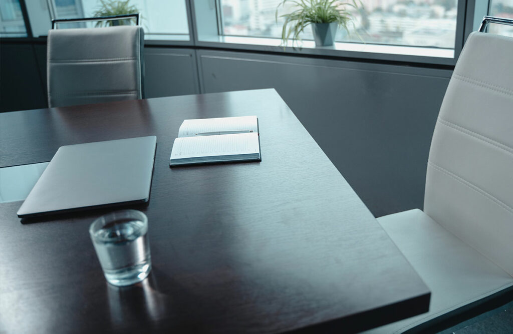 Close up of table with a notepad and laptop
